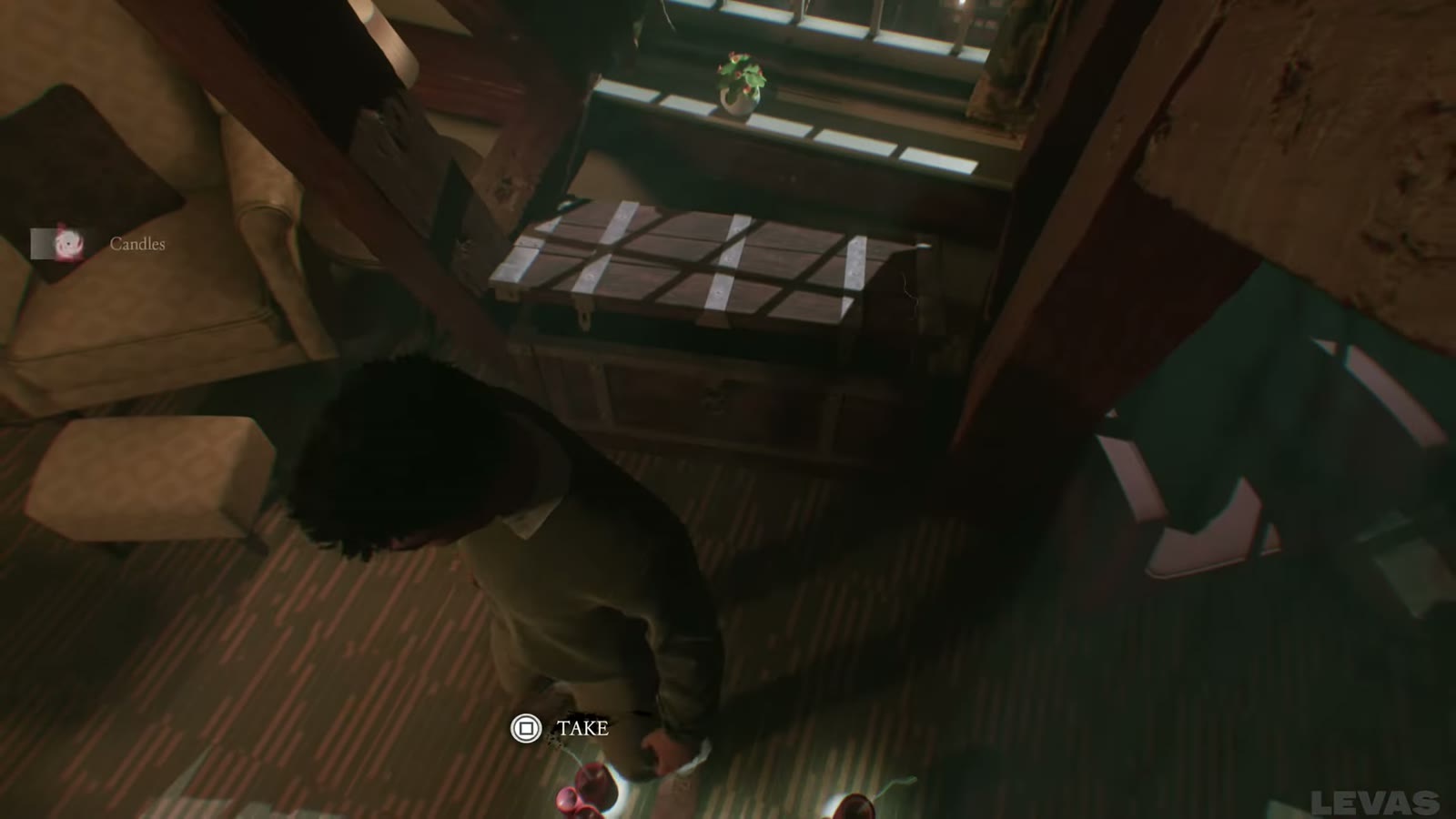 Take prompt on loose red candles on the floor in front of the window-side chest.